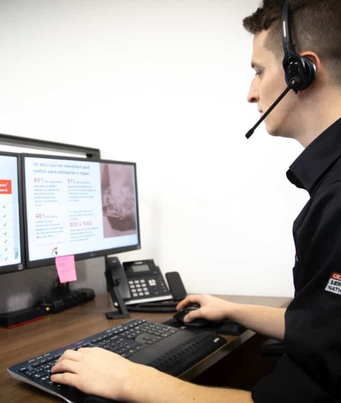 Un technicien en appel regarde ses écrans d'ordinateur